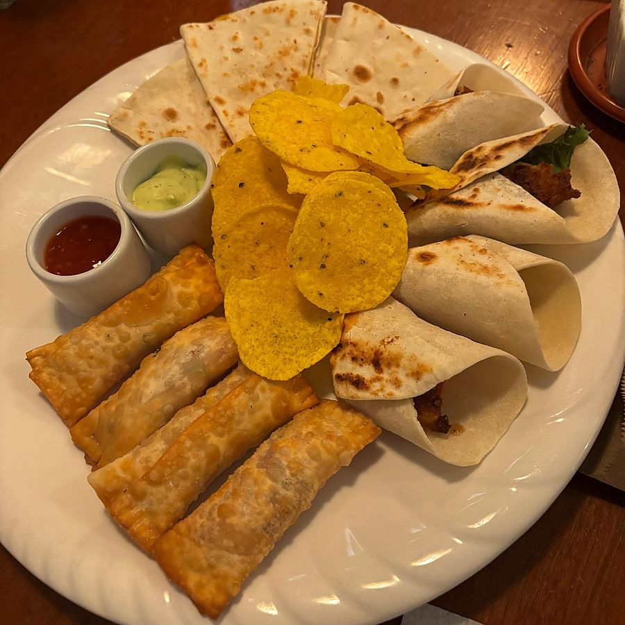 Plato para compartir con quesadillas, tacos, rollitos fritos y nachos