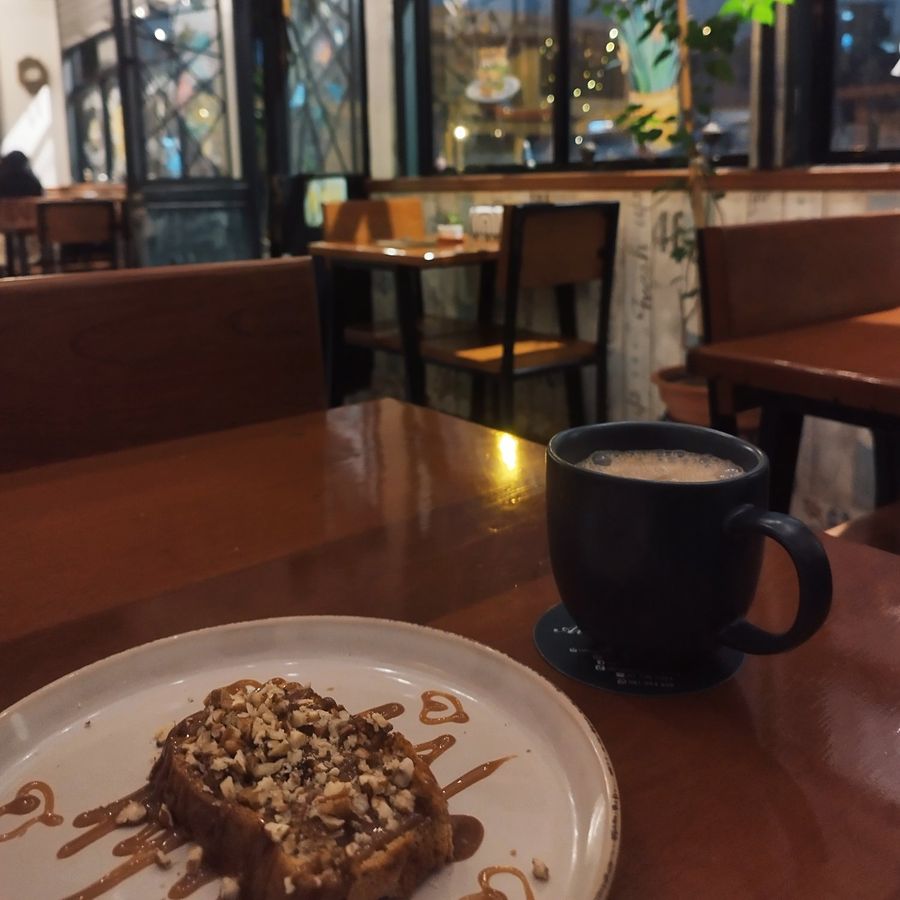 Mesa del salón con café y postre junto a los ventanales