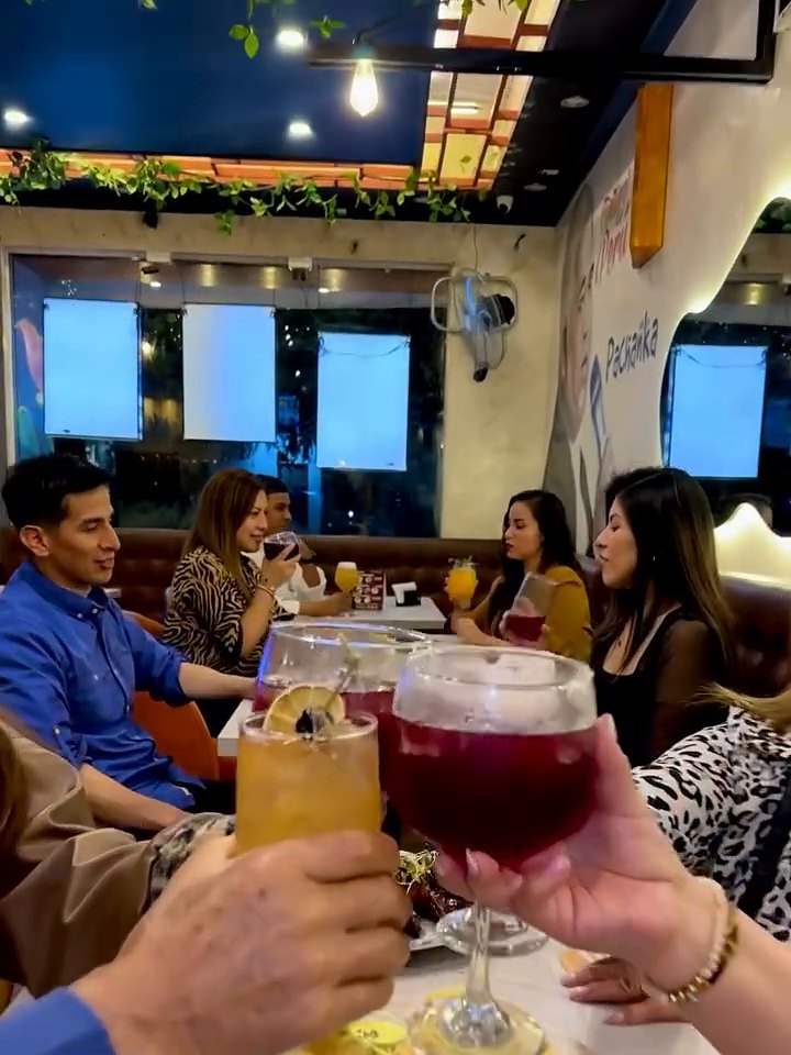 Brindis con bebidas de la casa en una mesa de Pachanka