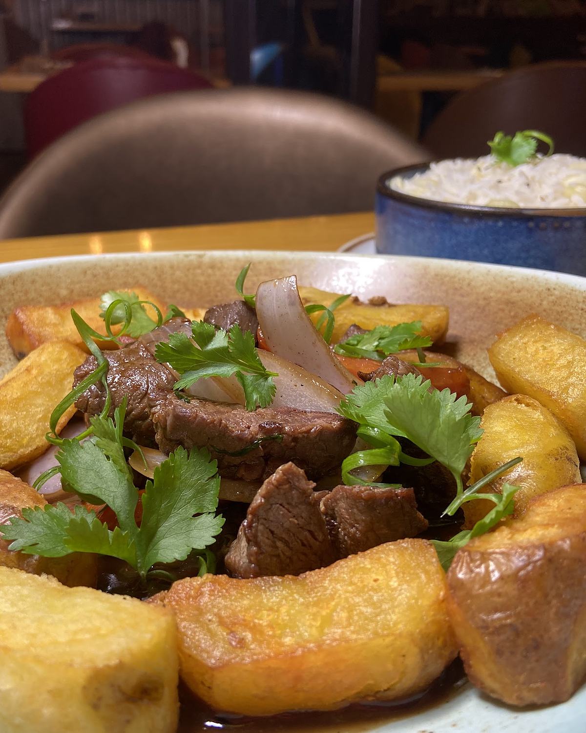 Lomo saltado con papas amarillas y arroz, servido en el salón de Pachanka