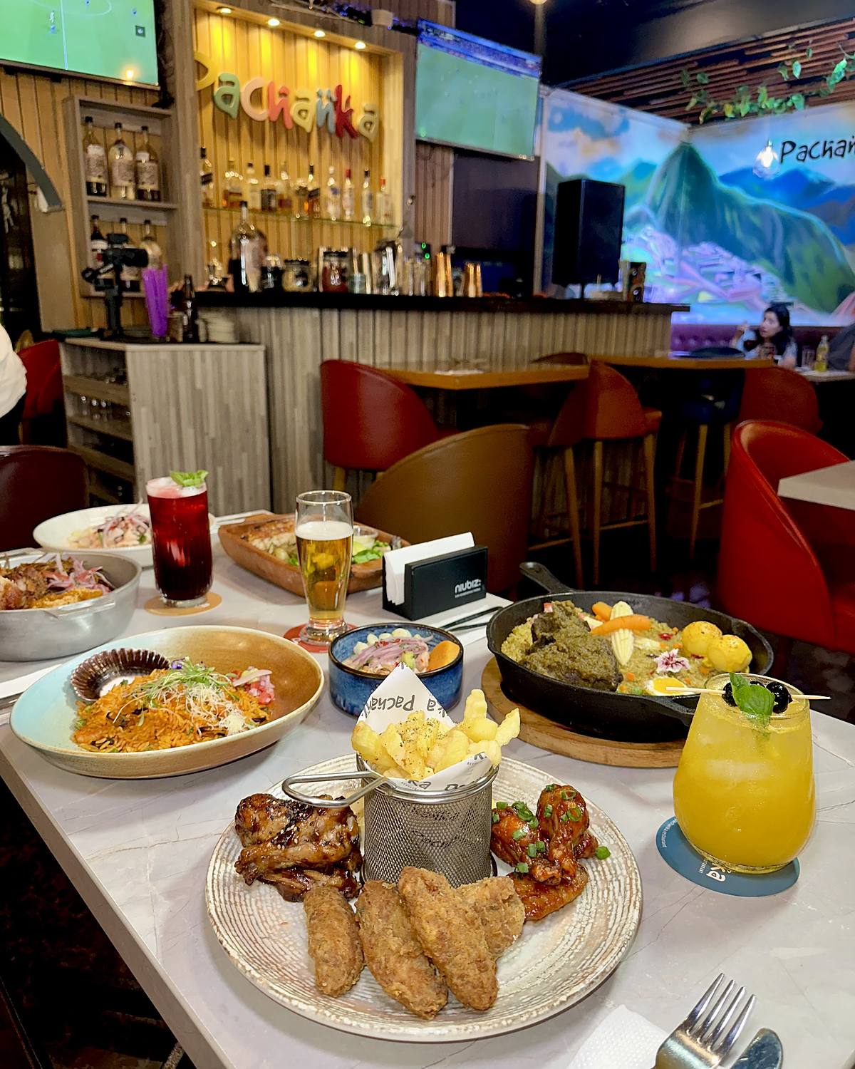 Mesa servida en el salón de Pachanka, con la barra al fondo